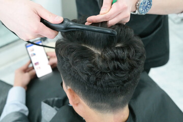 Close-up of a man's hair perming with a hairdressing tool