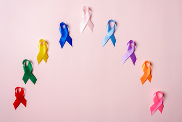 Multi colorful ribbons on pink background, cancer awareness, World cancer day, National cancer survivor day, world autism, supporting people living and illness, Prostate awareness concept.