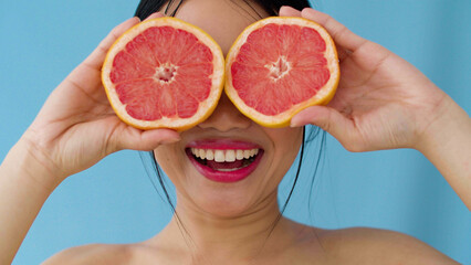 Joyful Asian Woman With Grapefruit Posing In Studio.