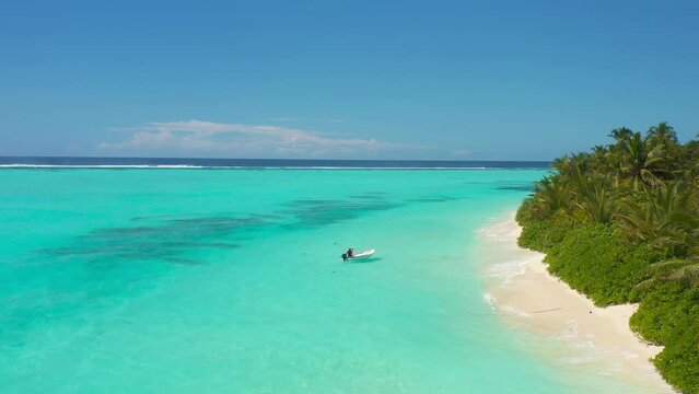Aerial view a fisherman on a boat at a paradise beach on Thoddoo island, Maldives.