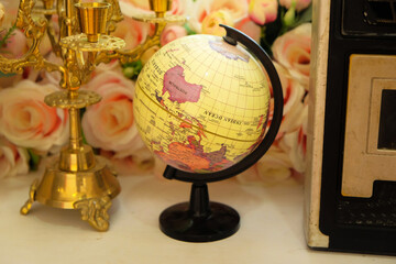 Globe on wooden table on colorful floral background