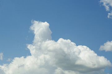 A white cloud in the shape of a man against a blue sky. Created by nature.