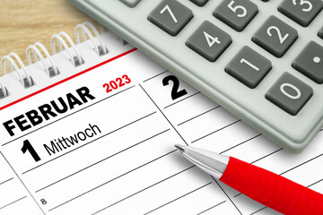 Deutscher Kalender Datum 1. Februar 2023 mit Rechner und rotem Kugelschreiber