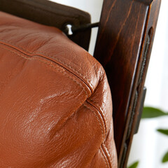Vintage bentwood frame lounge chair with rich cognac leather. Closeup wood seat detail.