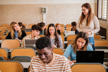 Group of university students attended individually by the teacher in the classroom