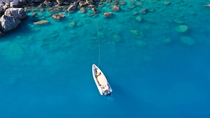Aerial drone photo of small inflatable rib speedboat anchored in beautiful bay of small fishing coastal village of Assos in island of Kefalonia, Ionian, Greece