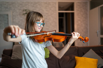 Portrait of cute little girl playing violin