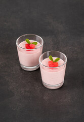 Red Plum Cream jelly dessert, Panna Cotta in a glass. Dark gray background