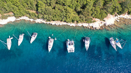 Aerial drone top down photo of sail boats and yachts anchored in traditional fishing village of...