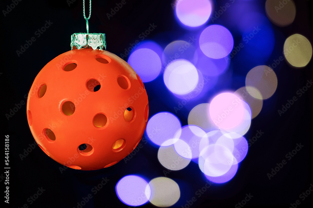 Wall mural Red Pickleball Christmas. Red Pickleball Christmas Ornament with Brokeh lights om a black background.