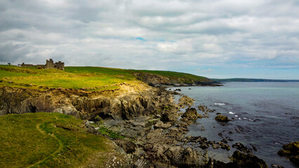 Obraz premium Overcast cloudy sky over the rocky coast of Ireland. Beautiful nature of northern Europe. Green fields on the coast. View from above.