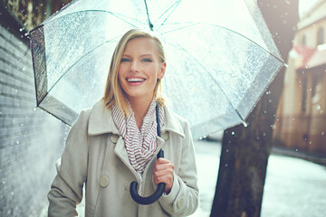 This weather wont get me down. Cropped portrait of an attractive young woman walking in the rain.