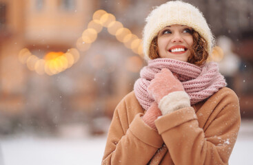 Beautiful woman outdoor during christmas time in front of christmas lights. Holidays, rest, travel concept.