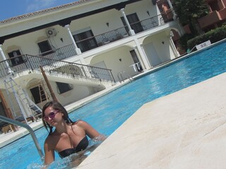 una mujer joven disfrutando de la piscina de un palacio 