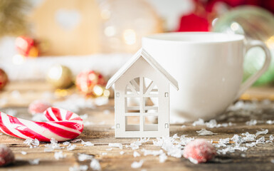 A little wooden house and Christmas decoration on wooden table.