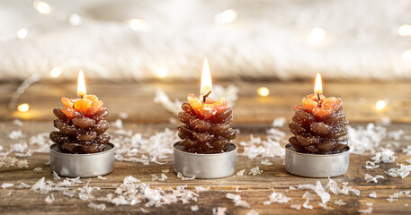 Christmas background with candles in the form of cones on a blurred background.