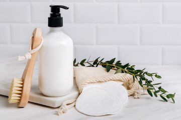 Bottles of shampoo, soap, shower gel, moisturizer, makeup remover and cotton reusable makeup remover pads. Showcase with a stage for products, mockup design