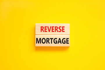Reverse mortgage symbol. Concept words Reverse mortgage on wooden blocks. Beautiful yellow table yellow background. Business and reverse mortgage concept. Copy space.