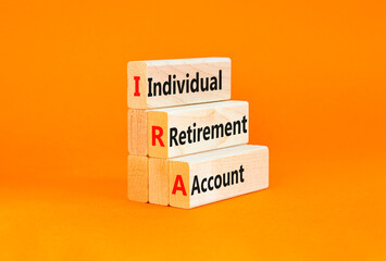 IRA individual retirement account symbol. Concept words IRA individual retirement account on wooden blocks on beautiful orange background. Business IRA individual retirement account concept Copy space