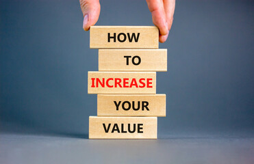 Increase your value symbol. Concept words How to increase your value on wooden blocks. Businessman hand. Beautiful grey table grey background. Business how to increase your value concept. Copy space.