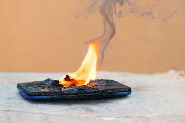Mobile phone in fire and smoke. Burned mobile phone