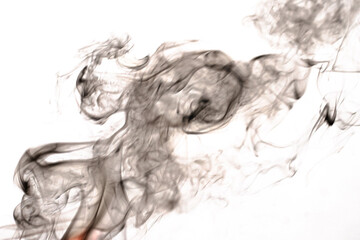 Fototapeta premium Dark thick smoke curling in rings on a light background