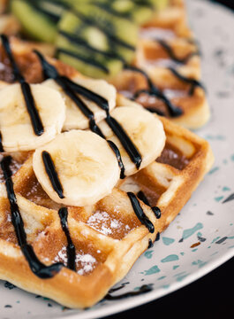 Close-up, Belgian waffles with fruits, covered with chocolate.