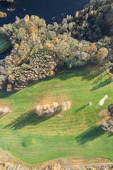 Aerial panoramic view of beautiful autumn morning, golf course, river, multicolored trees and green...