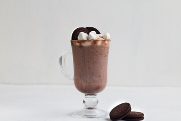 Delicious Hot Viennese Coffee In Glass Cup With Whipped Cream. Hot chocolate with marshmallow and cookie. Winter and autumn time. Christmas drink on the white background. copy space