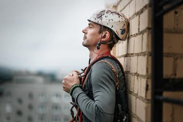 Male worker rope access industrial working at height tank oil wearing harness, helmet safety equipment rope