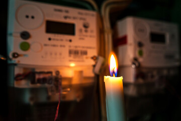 electricity meter illuminated by the light of a burning candle.