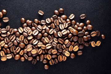 brown coffee beans lie on a black background