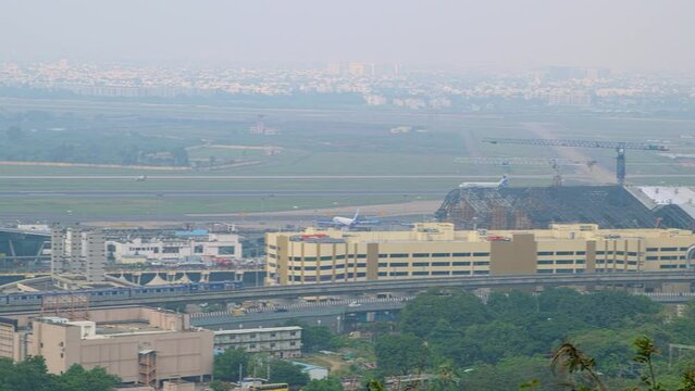 View of plane taking off from a runway, shot from a hilltop, view of cityscape 