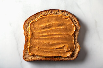 Open sandwich from slice of wholegrain bread with peanut nut butter
