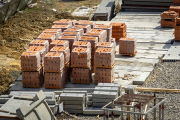 Red bricks are stacked on pallets at a construction site. Storage of building materials....