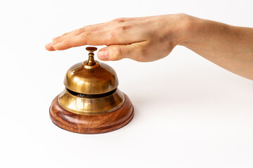 Fototapeta na wymiar Metal golden hotel service bell with hand. Attention concept