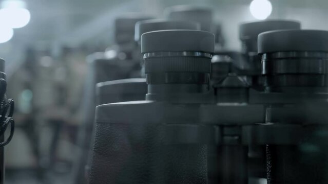 A lot of new modern high-approximation binoculars on the store counter. Closeup. Follow focus