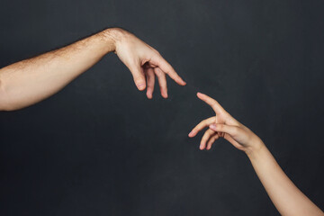 Two hands reach out to each other with index fingers. The concept of support, communication,...