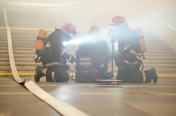 Rescuers lay out lighting equipment to work on a fire.