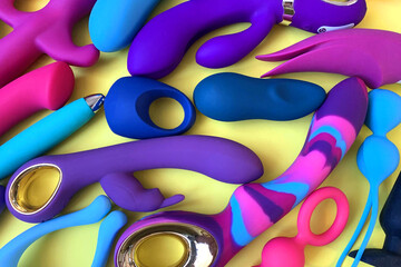 Sex toys. Sex shop assortment. Many vibrators on yellow background