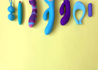 Blue sex toys. Sex shop assortment. Seven vibrators and jiggle balls on yellow background