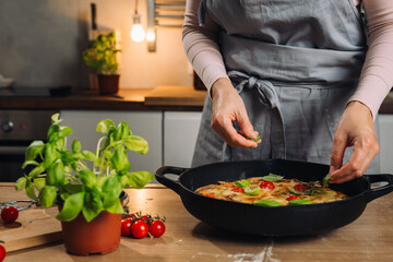 close up of woman add basil on pizza