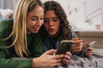 close up of female friends use mobile phone, looking at screen