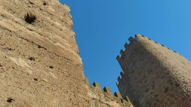 Vista inferior ruinas de torreones y muralla almenada del castillo de Burgalimar de origen musulm&aacute;n en la villa de Ba&ntilde;os de la Encina, Espa&ntilde;a