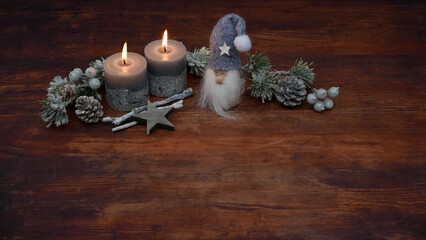 Weihnachts und Adventdekoration: Kerzen mit Wichtel auf Holzhintergrund mit Platz für Text.