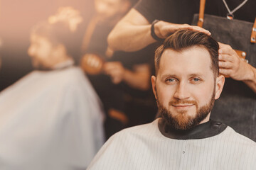 Portrait smile client man in barber chair, hairdresser styling hair. Concept barbershop banner,...