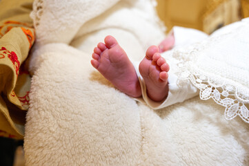 baptism of a child in the church, legs of a newborn baby, close-up of the rite of baptism....