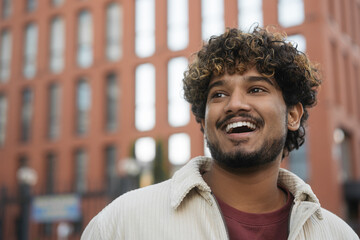 Portrait of smiling Indian man wearing casual clothing looking away, copy space. Happy handsome...