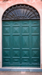Metal green door with iron wrought grating with window