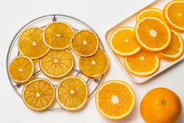 Fresh orange, fresh orange slices on plate. Dry orange slices on metal grill.